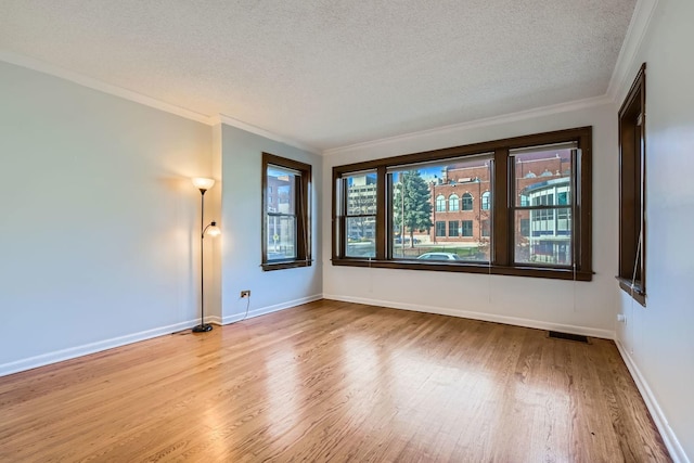 unfurnished room featuring a textured ceiling, wood finished floors, and visible vents