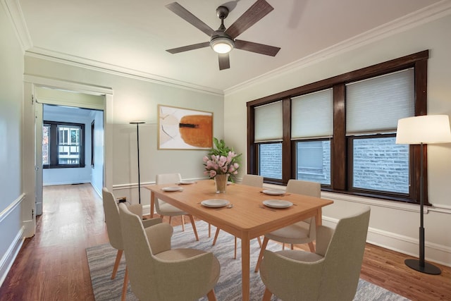 dining space with ornamental molding, a ceiling fan, and wood finished floors