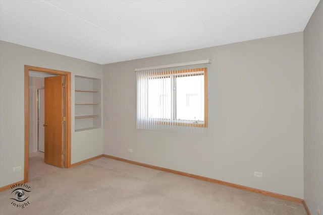 unfurnished bedroom with light colored carpet and baseboards