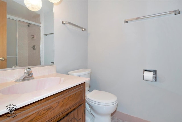 bathroom featuring a shower stall, toilet, and vanity