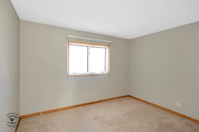 unfurnished room featuring light carpet and baseboards