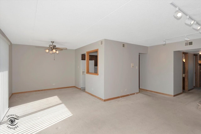 spare room featuring ceiling fan, baseboards, visible vents, and light colored carpet