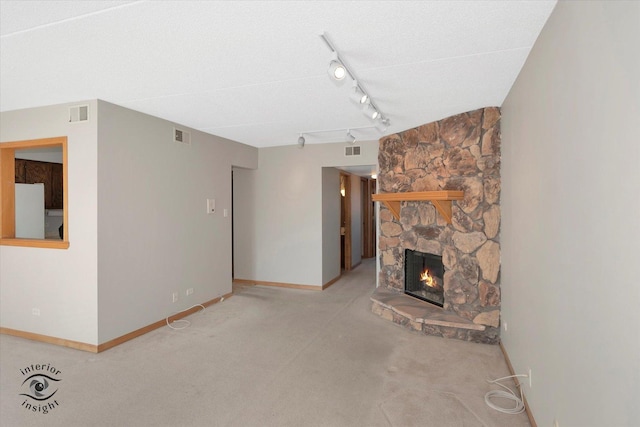 8136 168th Pl Unit 2W, Tinley Park, IL 60477 - unfurnished living room with a fireplace, baseboards, carpet flooring, and rail lighting