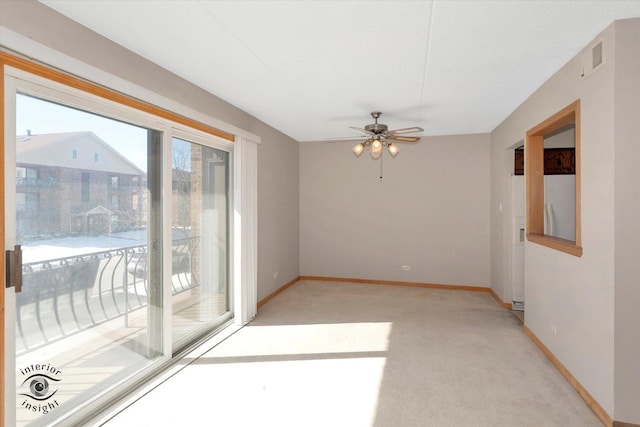 spare room featuring baseboards, ceiling fan, visible vents, and light colored carpet