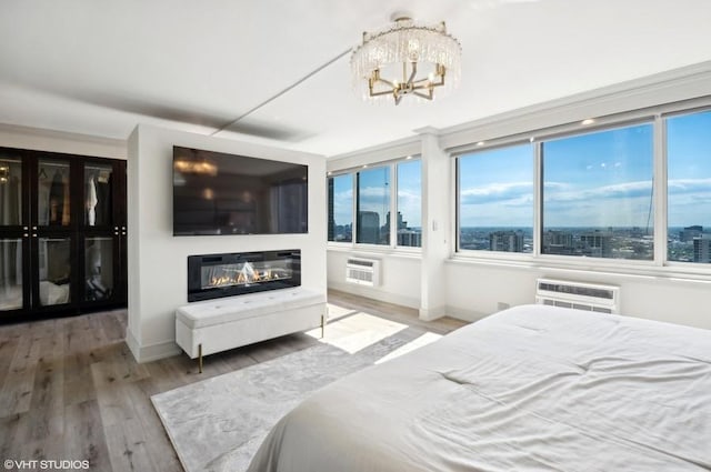 bedroom with a chandelier, an AC wall unit, and hardwood / wood-style floors