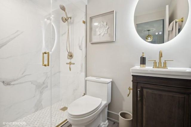 bathroom featuring vanity, toilet, and a shower with shower door