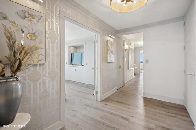 hallway with ornamental molding and light wood-type flooring