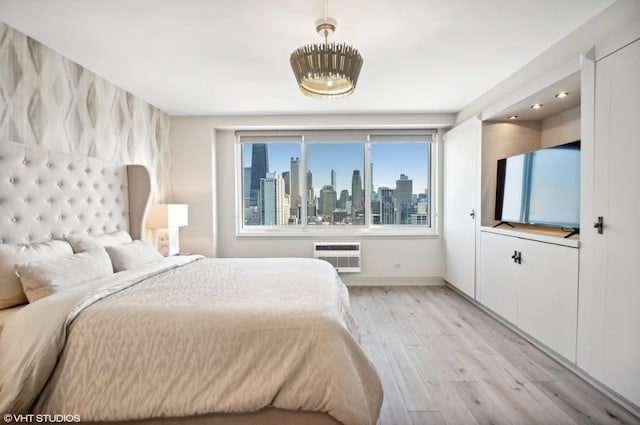 bedroom featuring a wall unit AC and light hardwood / wood-style floors