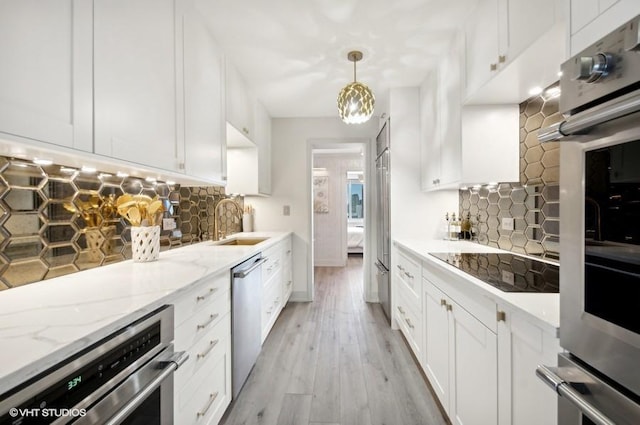 kitchen with white cabinetry, sink, pendant lighting, and appliances with stainless steel finishes