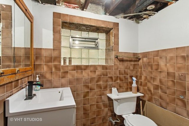 bathroom featuring toilet, tile walls, and vanity