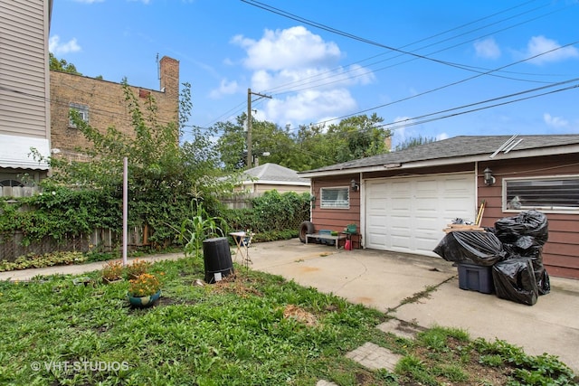 garage featuring fence and driveway