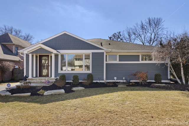 view of front of property featuring a shingled roof and a front lawn