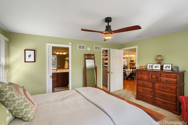 carpeted bedroom with ensuite bathroom, a spacious closet, a closet, and visible vents