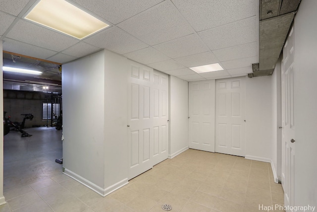 below grade area featuring a paneled ceiling and baseboards