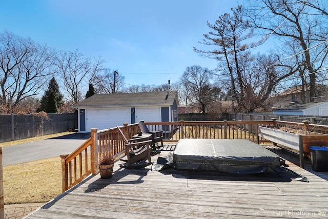 wooden deck with a garage, a fenced backyard, and an outdoor structure