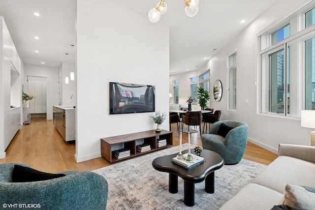 living area featuring recessed lighting, light wood-style flooring, and baseboards