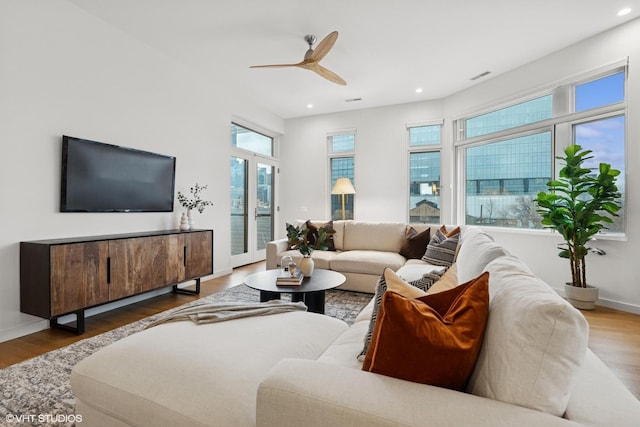 living area with recessed lighting, visible vents, a ceiling fan, wood finished floors, and baseboards