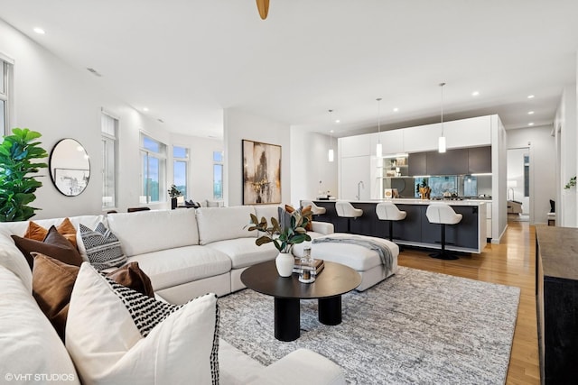 living area with recessed lighting and light wood-style flooring