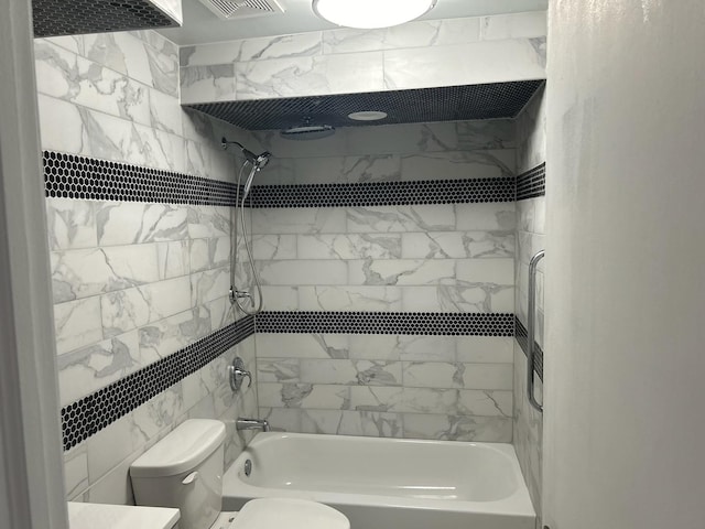 bathroom featuring tiled shower / bath and toilet