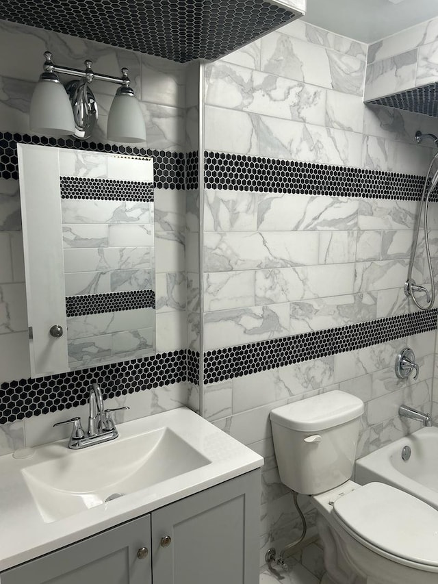 full bathroom featuring shower / washtub combination, vanity, tile walls, and toilet