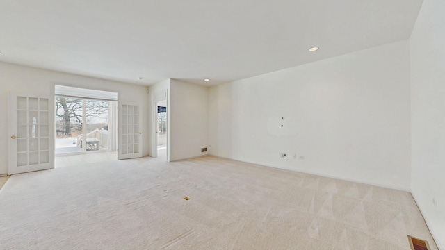 spare room featuring light carpet, recessed lighting, visible vents, and french doors