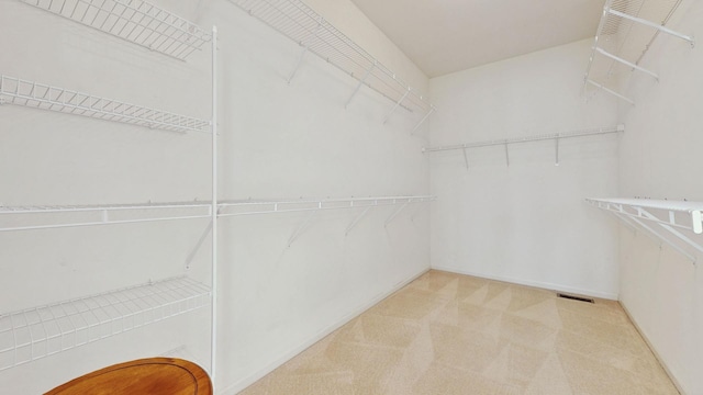 spacious closet featuring visible vents and light colored carpet