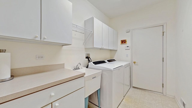 laundry area with visible vents, cabinet space, washer and clothes dryer, and light floors