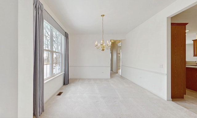 unfurnished room with light carpet, a notable chandelier, and visible vents