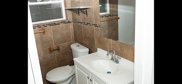 bathroom featuring tile walls, toilet, and vanity