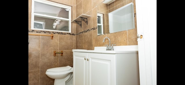 bathroom with tile walls, vanity, and toilet