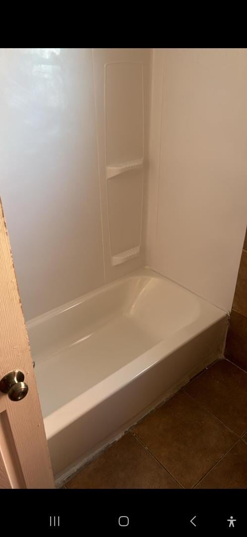 bathroom featuring tile patterned flooring and a washtub