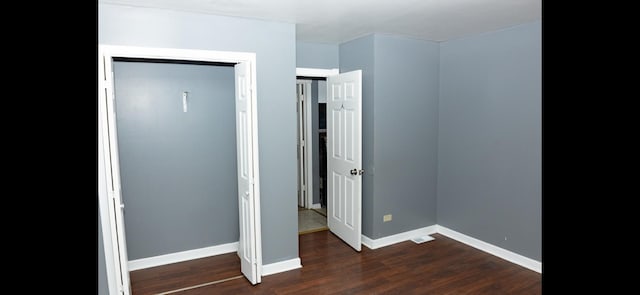 unfurnished bedroom featuring a closet and dark hardwood / wood-style floors