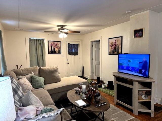 living room featuring ceiling fan and dark hardwood / wood-style floors