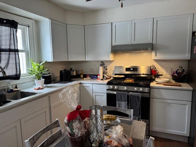 kitchen with white cabinets, ceiling fan, and stainless steel gas range