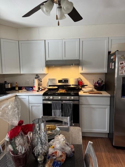 kitchen with appliances with stainless steel finishes, ceiling fan, dark hardwood / wood-style floors, and white cabinets