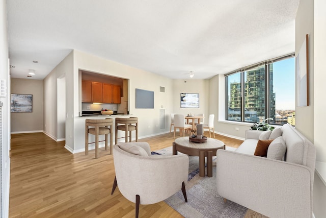 living room with a textured ceiling and light wood-type flooring