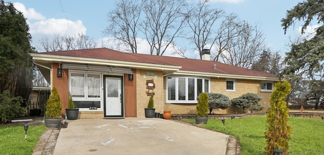 back of property with brick siding and a lawn