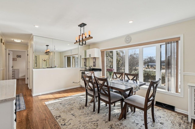 dining room featuring wood finished floors, visible vents, baseboards, recessed lighting, and a notable chandelier