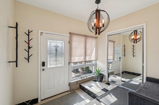 tiled foyer entrance with an inviting chandelier