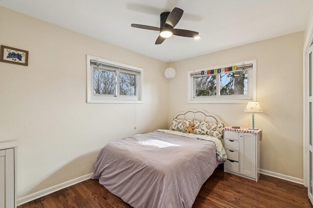 bedroom with ceiling fan, baseboards, and dark wood-style flooring