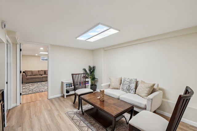 living area featuring baseboards and light wood-style flooring