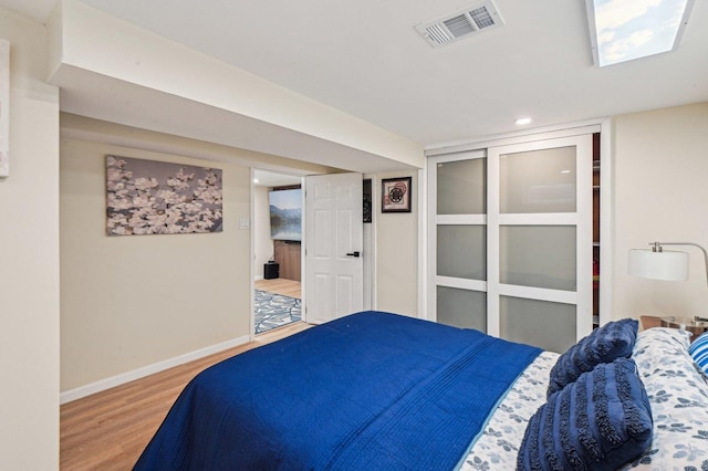 bedroom featuring visible vents, baseboards, and wood finished floors