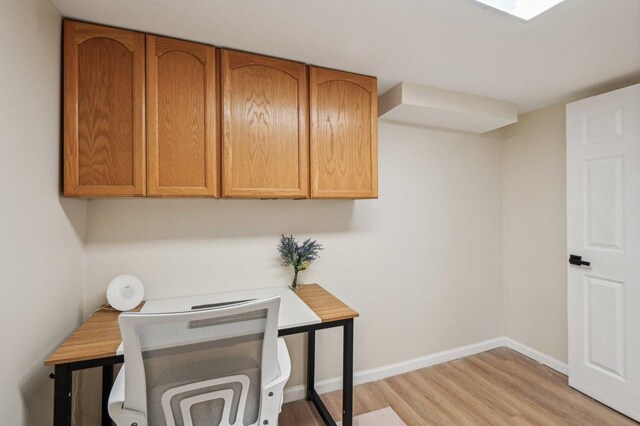 office with baseboards and light wood-style flooring