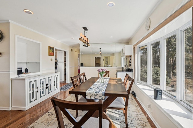 dining area with recessed lighting, crown molding, and wood finished floors