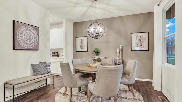 dining space with an inviting chandelier and dark wood-type flooring