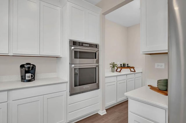 kitchen featuring white cabinetry, stainless steel appliances, and wood-type flooring