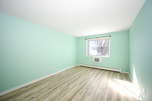 unfurnished room with light hardwood / wood-style flooring and a baseboard heating unit