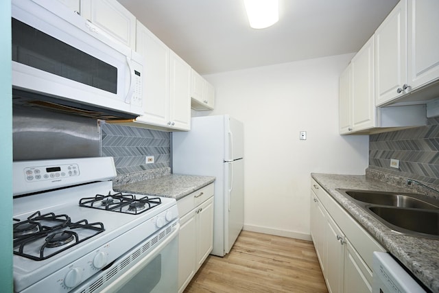 kitchen featuring sink, backsplash, white appliances, and white cabinets