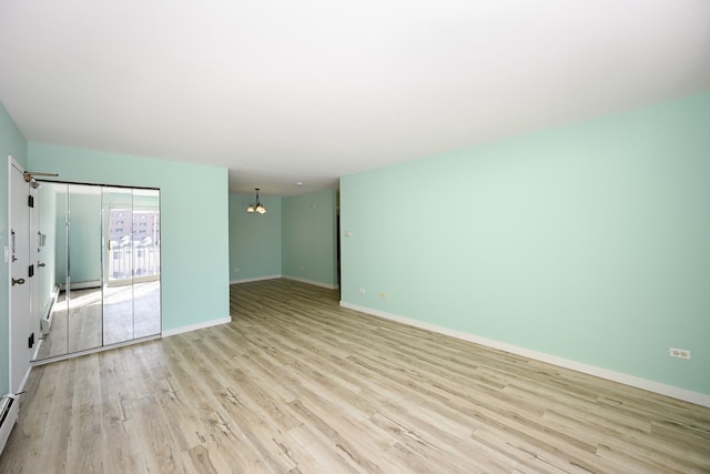 spare room with light wood-type flooring and baseboard heating