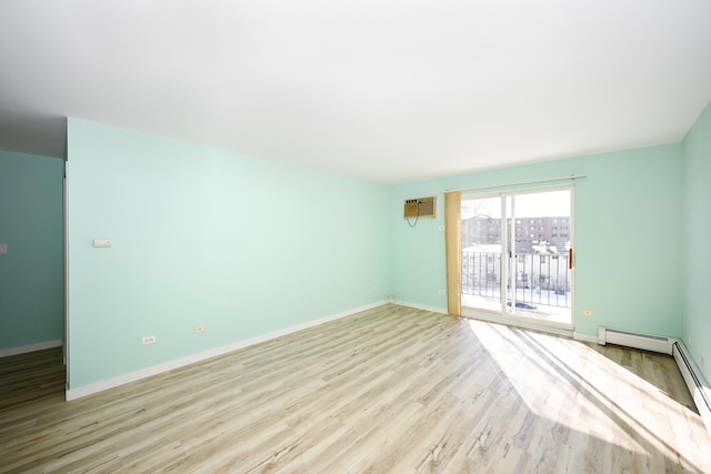 spare room with a wall mounted AC and light hardwood / wood-style floors